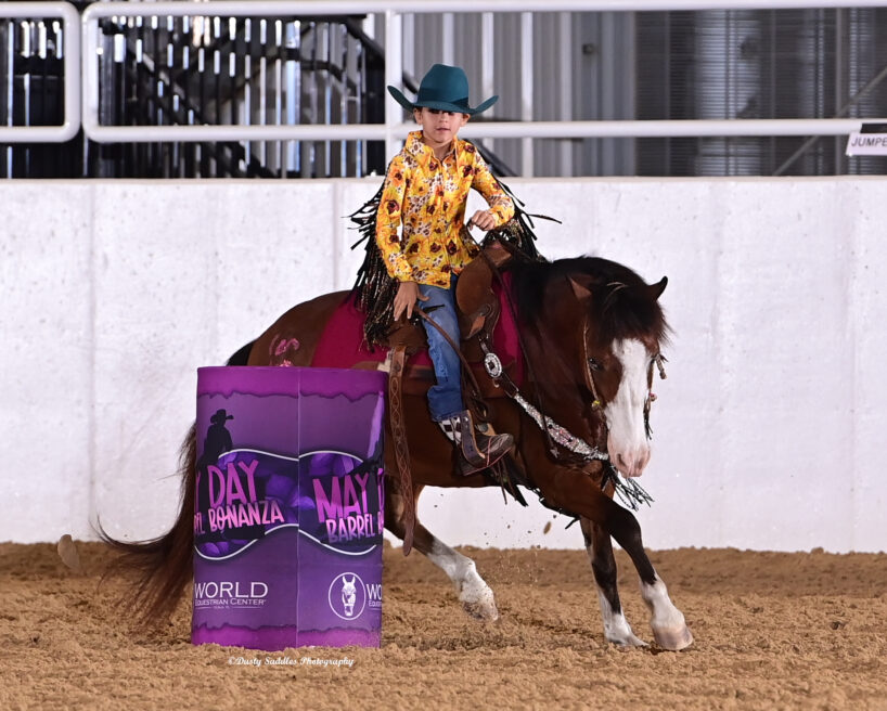 Child barrel racing at a western horse show.