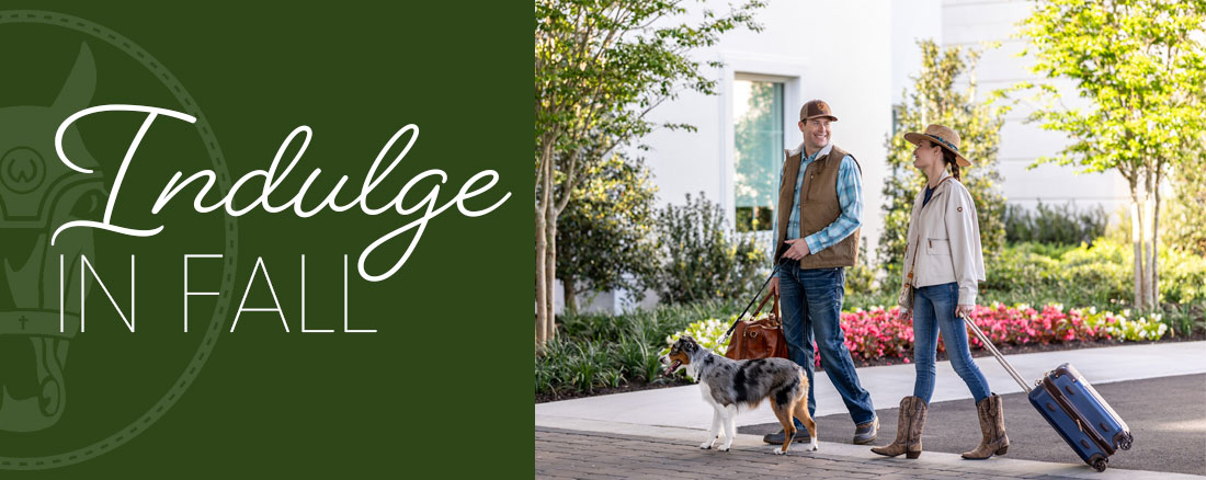 Indulge in Fall offer hear, couple with a dog walking to hotel front door. 