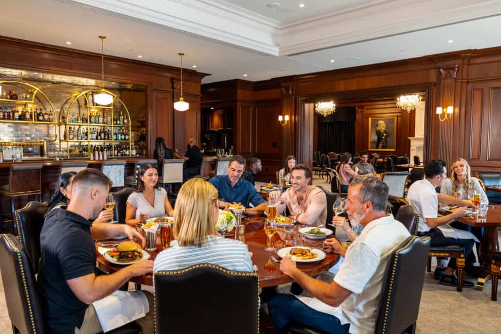 Guests dining in The Polo Pony dining room and patrons sitting at the bar in the background.