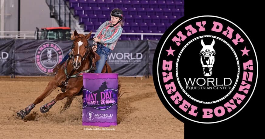 A rider in a striped shirt rounds a barrel on horseback at the May Day Barrel Bonanza event, with the event logo displayed beside the action.