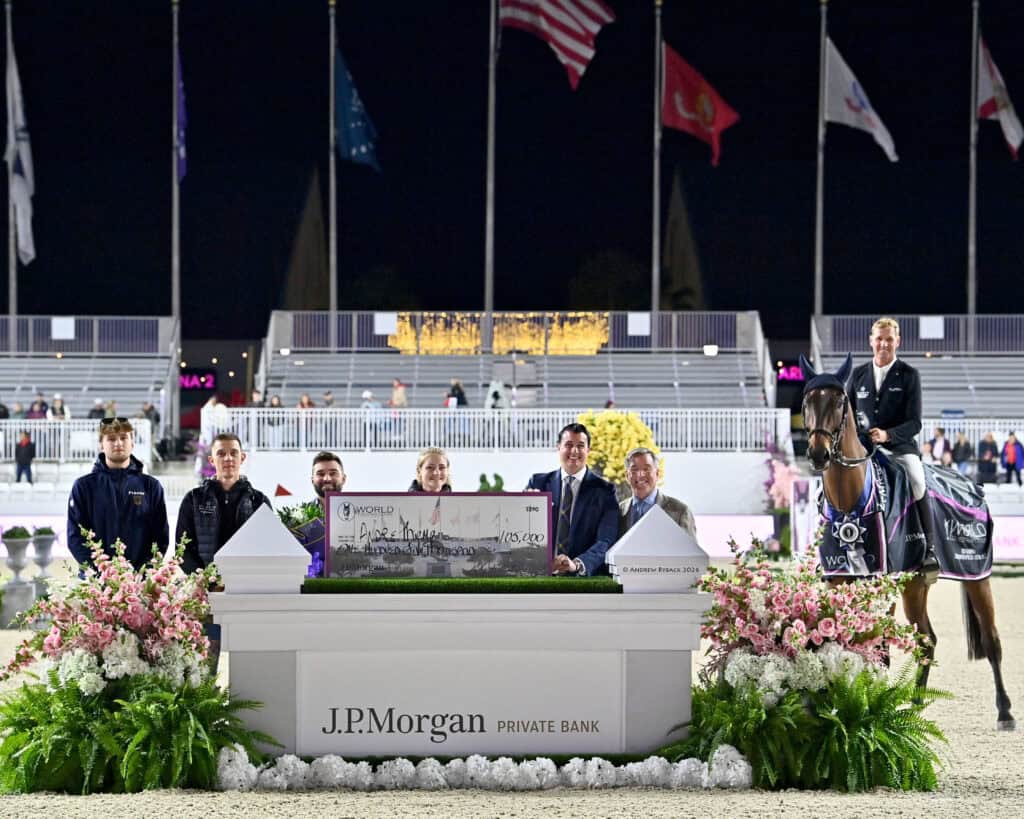 A group of people and a person on horseback pose behind a large check at a J.P. Morgan Private Bank event, with flags and stadium seating in the background.