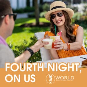 Two people sit outside at a table, smiling and toasting with drinks. Text reads, 