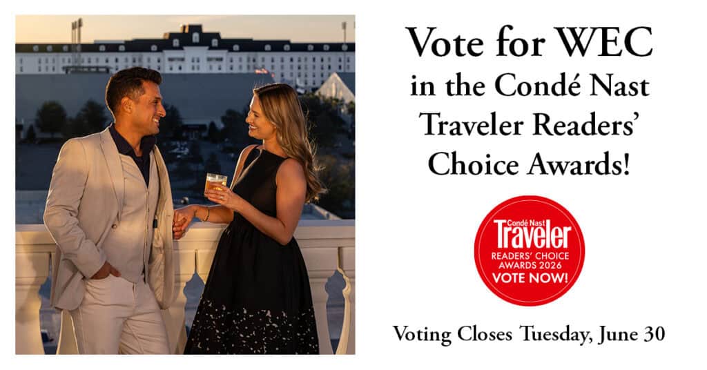 A man and woman in formal attire stand outdoors with drinks, smiling, as a building is visible behind them. Text promotes voting for WEC in the Condé Nast Traveler Readers’ Choice Awards.