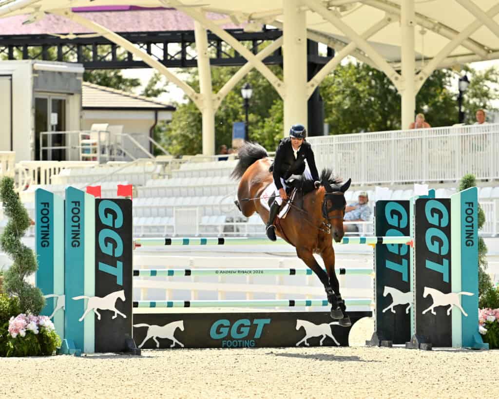 A rider and horse mid-jump over an obstacle labeled 