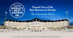 The Equestrian Hotel exterior at dusk with bright lights, featuring signage about being named one of the best resorts in Florida by Travel + Leisure World's Best Awards 2026.