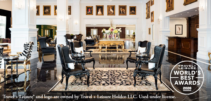 Elegant hotel lobby with black and white decor, large floral centerpiece, armchairs, framed art on white walls, and a "World's Best Awards 2026" badge in the bottom right corner.