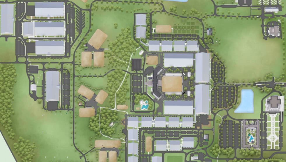 Aerial view of a large campus with multiple buildings, parking lots, roads, lawns, trees, walking paths, and fountains throughout the area.