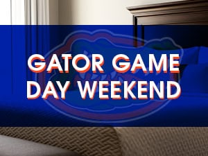 Text “Gator Game Day Weekend” over a blue semi-transparent box with a gator logo, overlaying a photo of a neatly made bed and headboard.