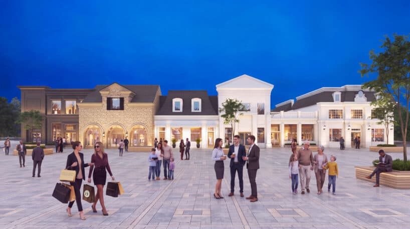 People walk, shop, and converse in a well-lit outdoor plaza with upscale shops, groups, families, and trees visible under a deep blue evening sky.