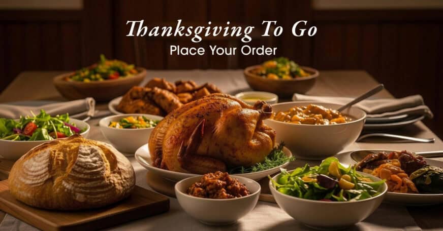 A Thanksgiving meal with roast turkey, salads, bread, and various side dishes on a table, with the text “Thanksgiving To Go Place Your Order” above the spread.