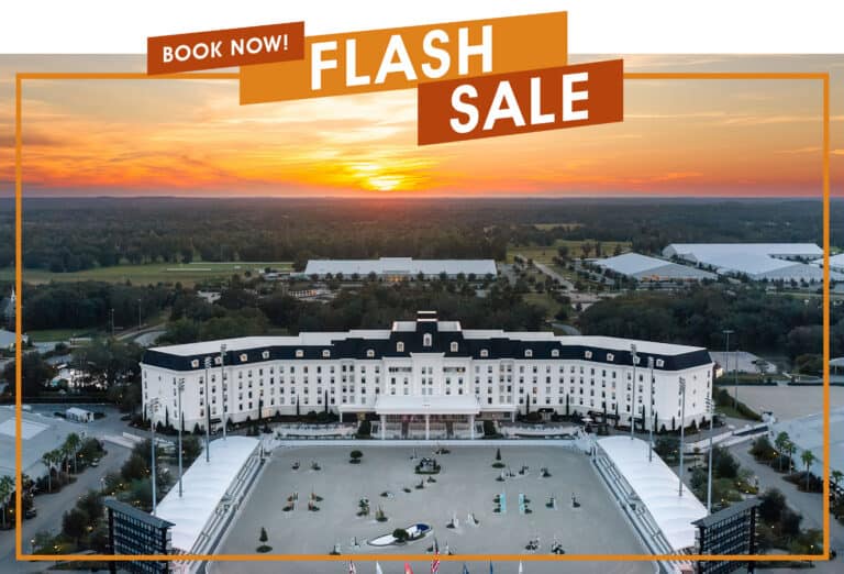 Aerial view of a large resort hotel next to an equestrian arena at sunset, with an orange overlay reading “BOOK NOW! FLASH SALE.”
